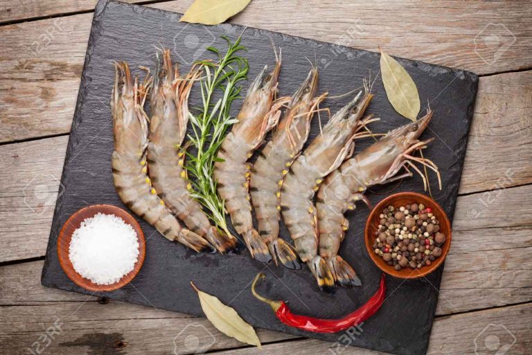 42663568-Fresh-raw-tiger-prawns-and-spices-on-black-stone-plate-over-wooden-table-Stock-Photo (123rf)